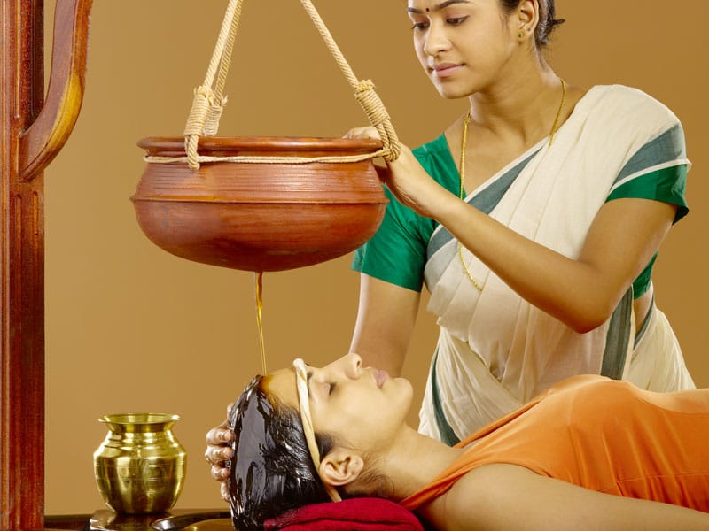 Shirodhara therapy - warm medicated oil being poured on forehead for stress relief